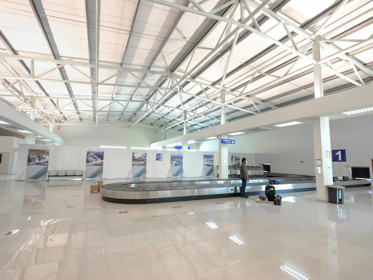 Airport baggage claim hall where international travelers wait for checked luggage