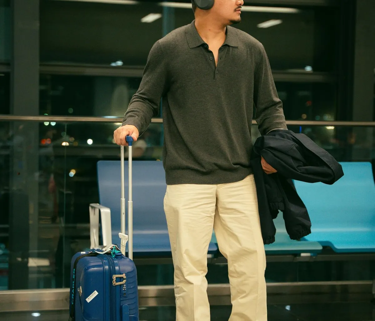 International traveler waiting in an airport terminal while checking arrival support messages