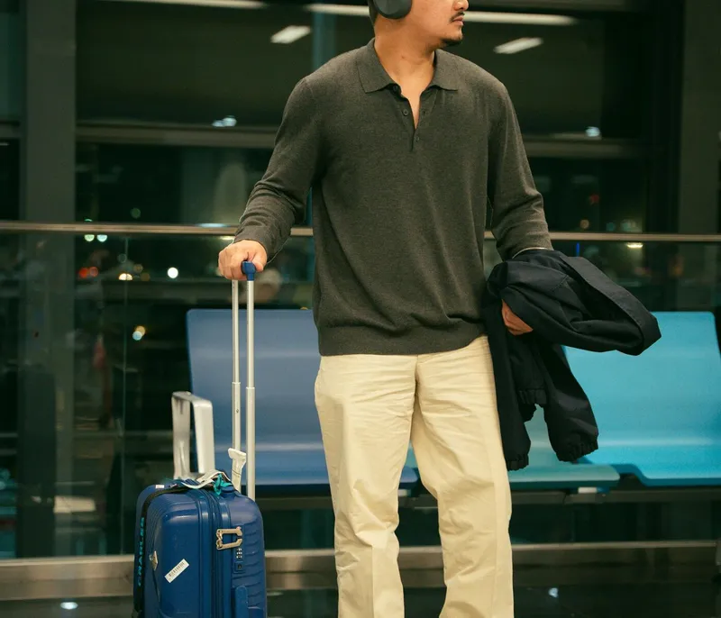 International traveler waiting in an airport terminal while checking arrival support messages