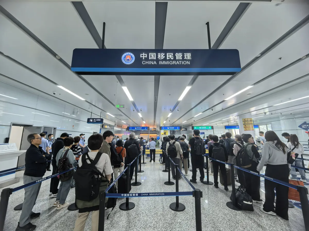 International travelers queue at a China immigration inspection area after arrival