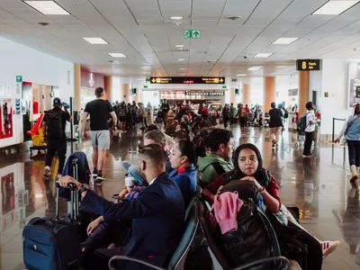 Travelers waiting in an airport terminal during a flight delay or gate change
