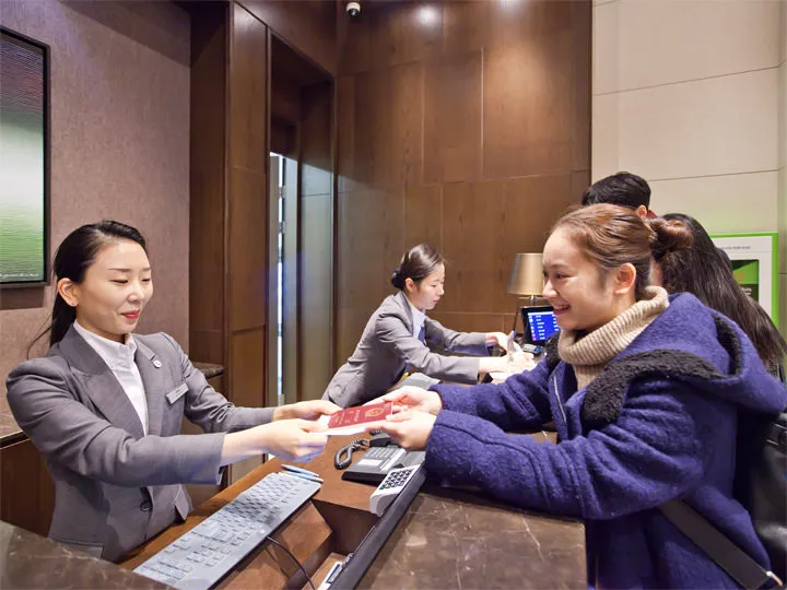 Hotel front desk checking traveler information before China trip arrangements are confirmed