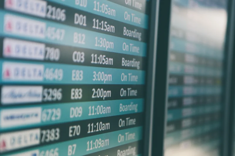 Airport departure board showing travel timing that may affect booking changes