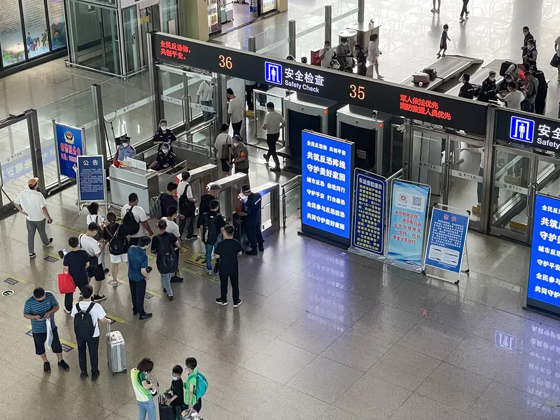 Railway station security check showing baggage screening before train travel in China